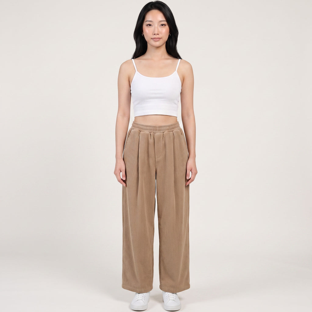 Model wearing Y2K Avenue beige wide-leg corduroy trousers with an elasticated waist, paired with a white cropped top