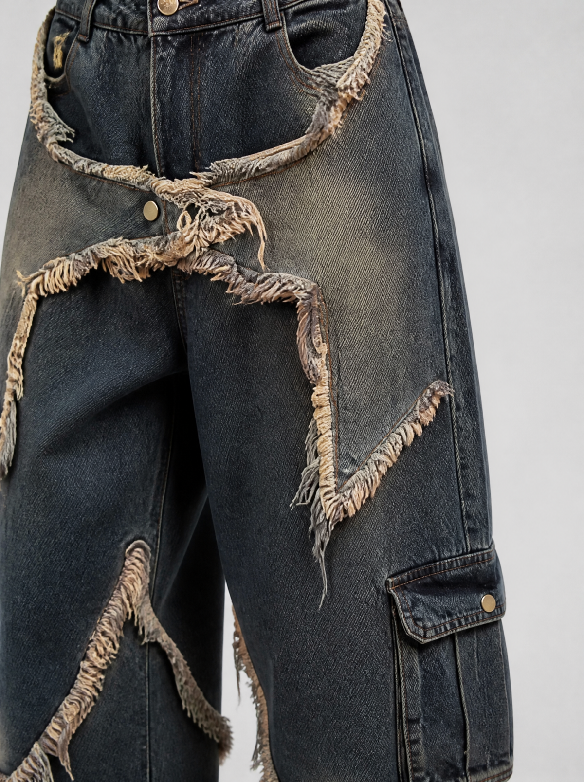 Photo détail | Gros plan sur une étoile en denim effiloché et la poche cargo du jean baggy bleu délavé