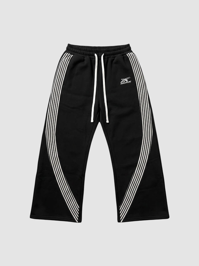 Jogging baggy en molleton noir avec bandes latérales blanches et logo brodé sur la cuisse gauche.