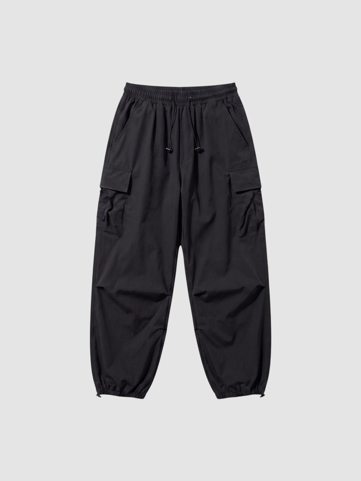 Pantalon cargo parachute noir coupe ample avec taille élastique à cordon et poches à rabat sur les côtés.