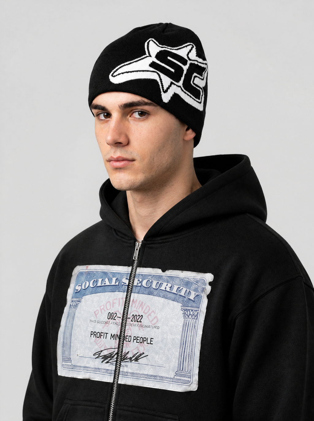 Autre vue | Bonnet noir à étoile blanche et lettres SC porté de trois quarts avec un sweat zippé noir carte sécurité sociale | Variante : Noir