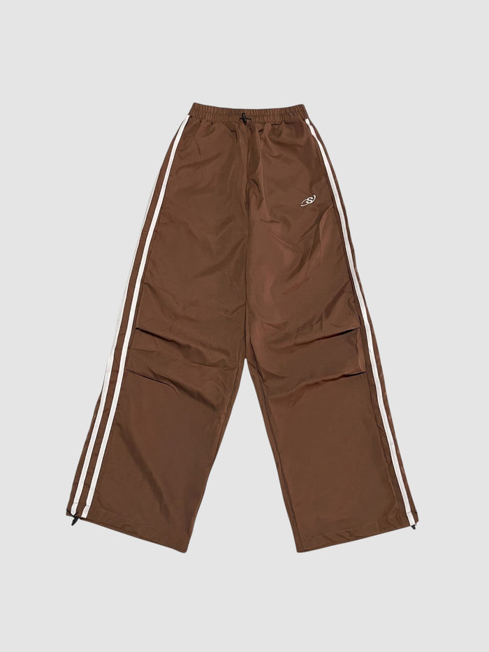 Jogging oversize marron en nylon avec bandes latérales blanches et taille haute élastique à cordon.