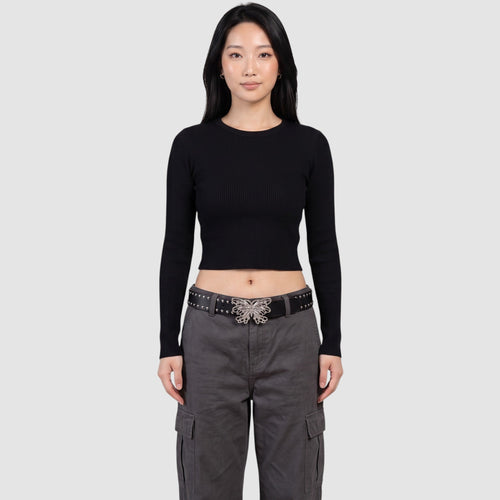 Ceinture noire cloutée en cuir synthétique avec boucle papillon en filigrane argenté, portée par un modèle en pantalon cargo gris.