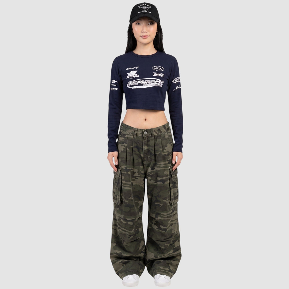 Pantalon cargo camouflage taille haute avec poches latérales et jambe large, porté par un modèle.