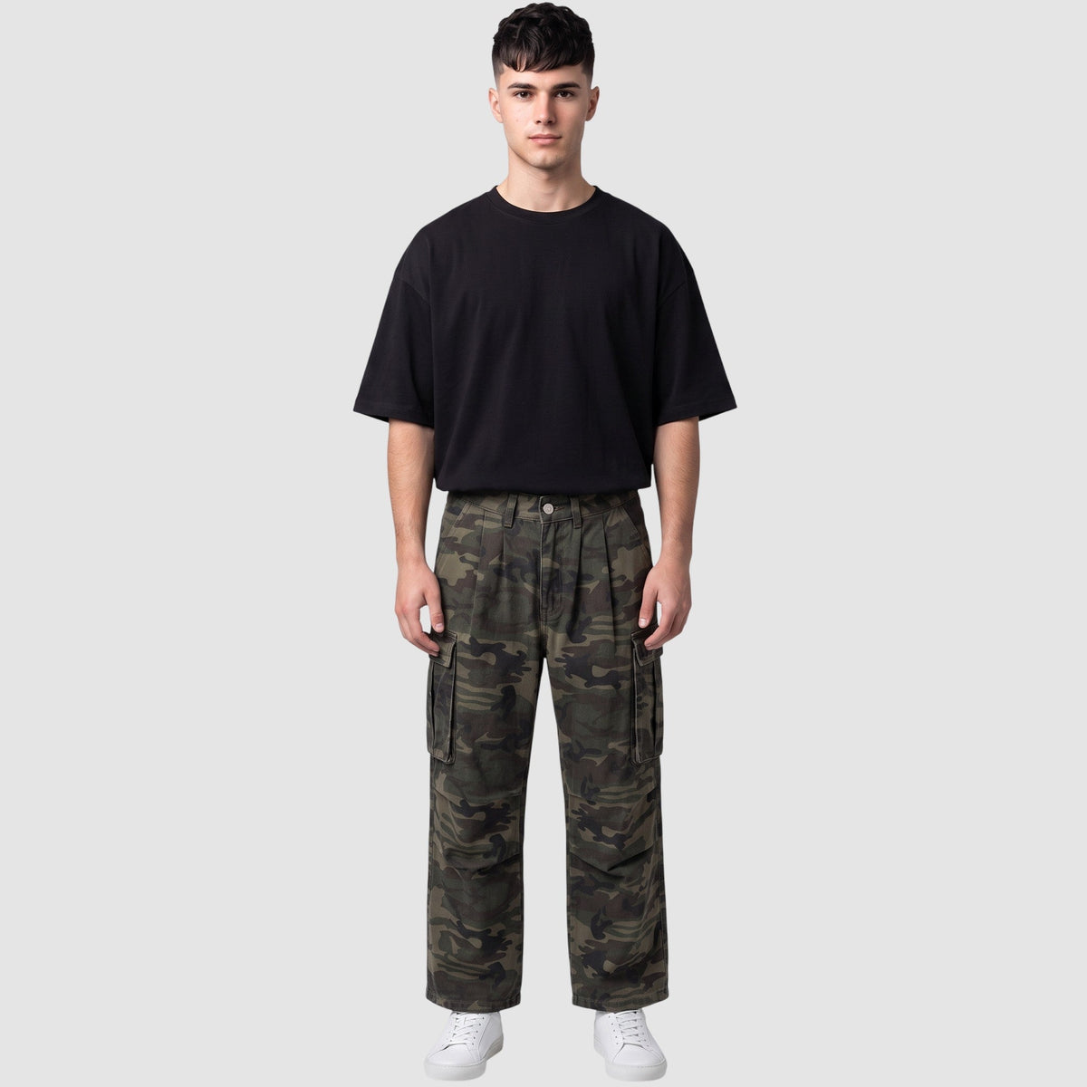 Modèle portant un pantalon cargo camouflage taille haute avec poches latérales et un t-shirt noir.