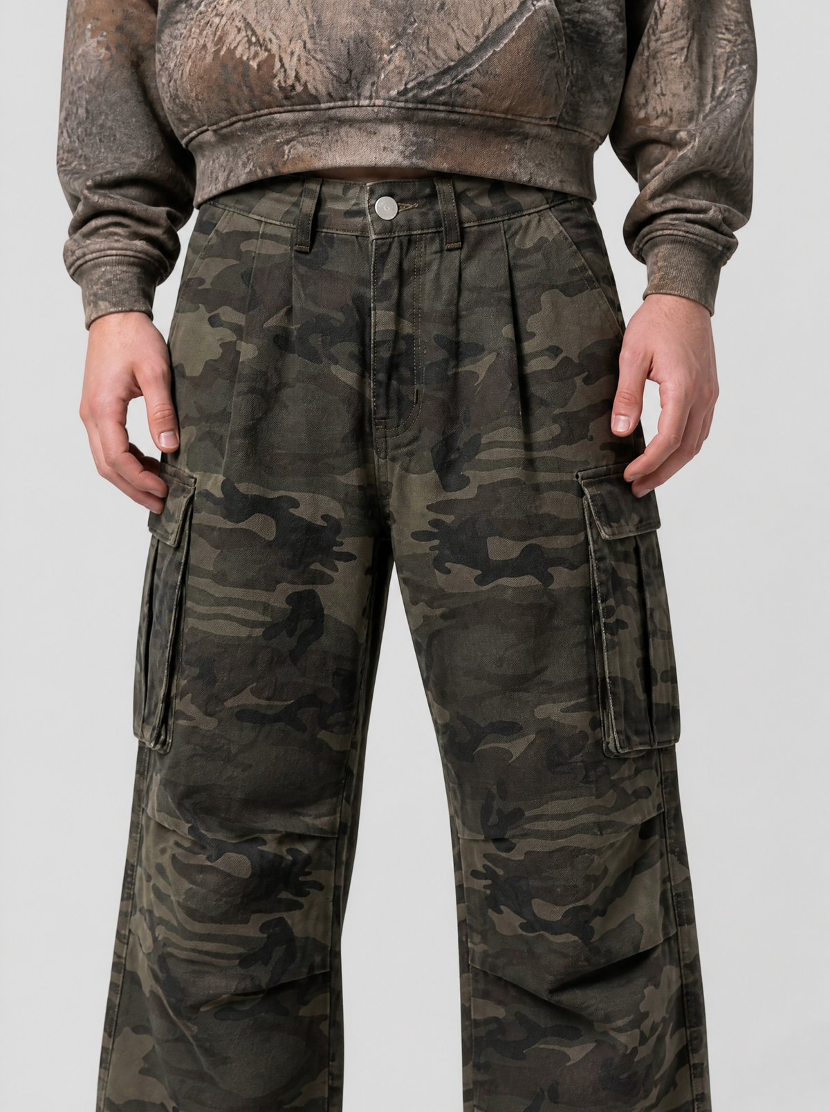 Photo détail | Gros plan sur l’imprimé camouflage, les pinces à la taille et une poche cargo à rabat du pantalon