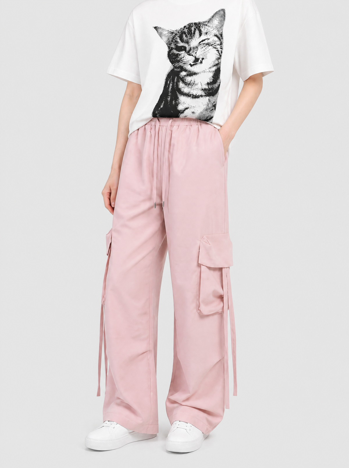Autre vue | Pantalon cargo rose pastel à poches à rabat et sangles porté de trois quarts avec un t-shirt blanc imprimé chat