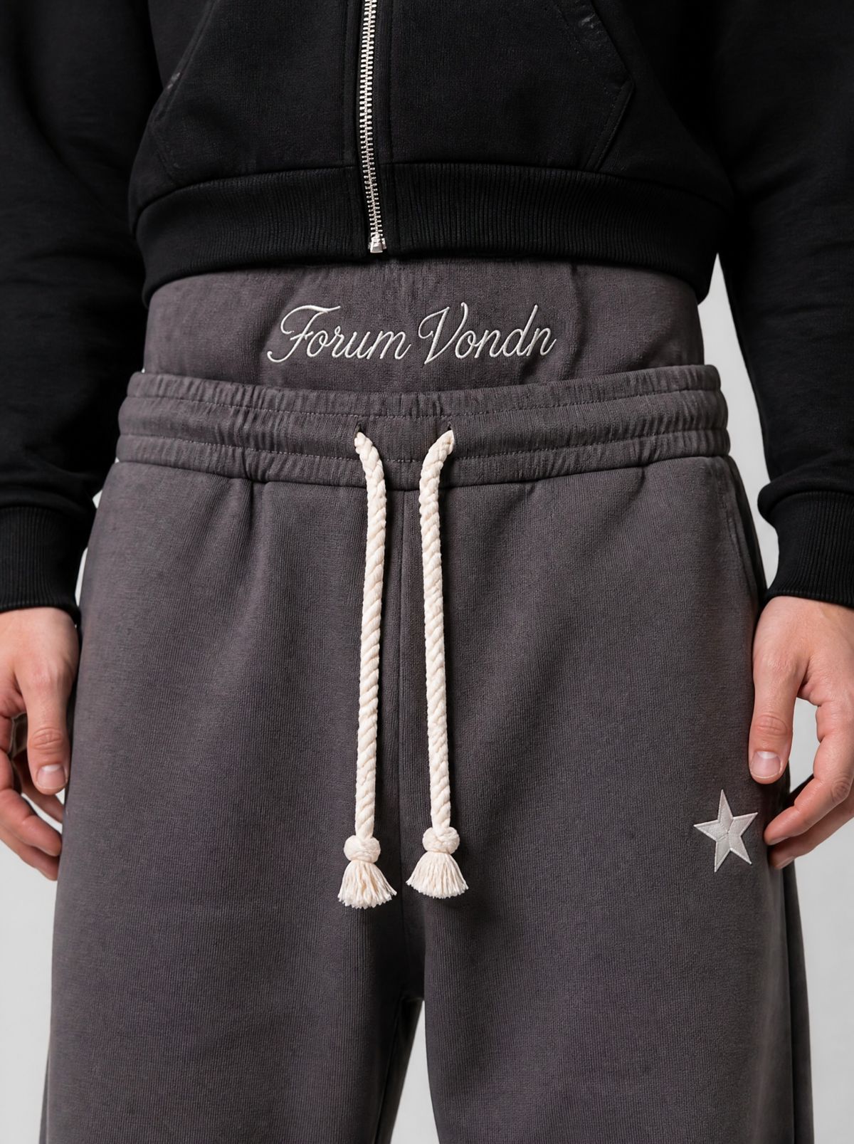Photo détail | Gros plan sur la double ceinture brodée en script blanc et le cordon crème du jogging gris | Variante : Gris
