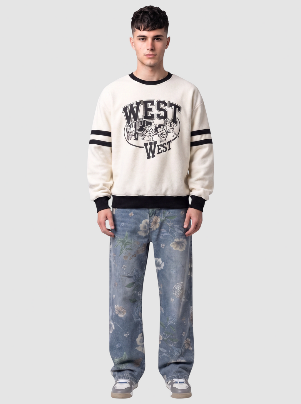 Modèle portant un sweat écru avec graphisme West et un jean carpenter bleu clair à imprimé floral.