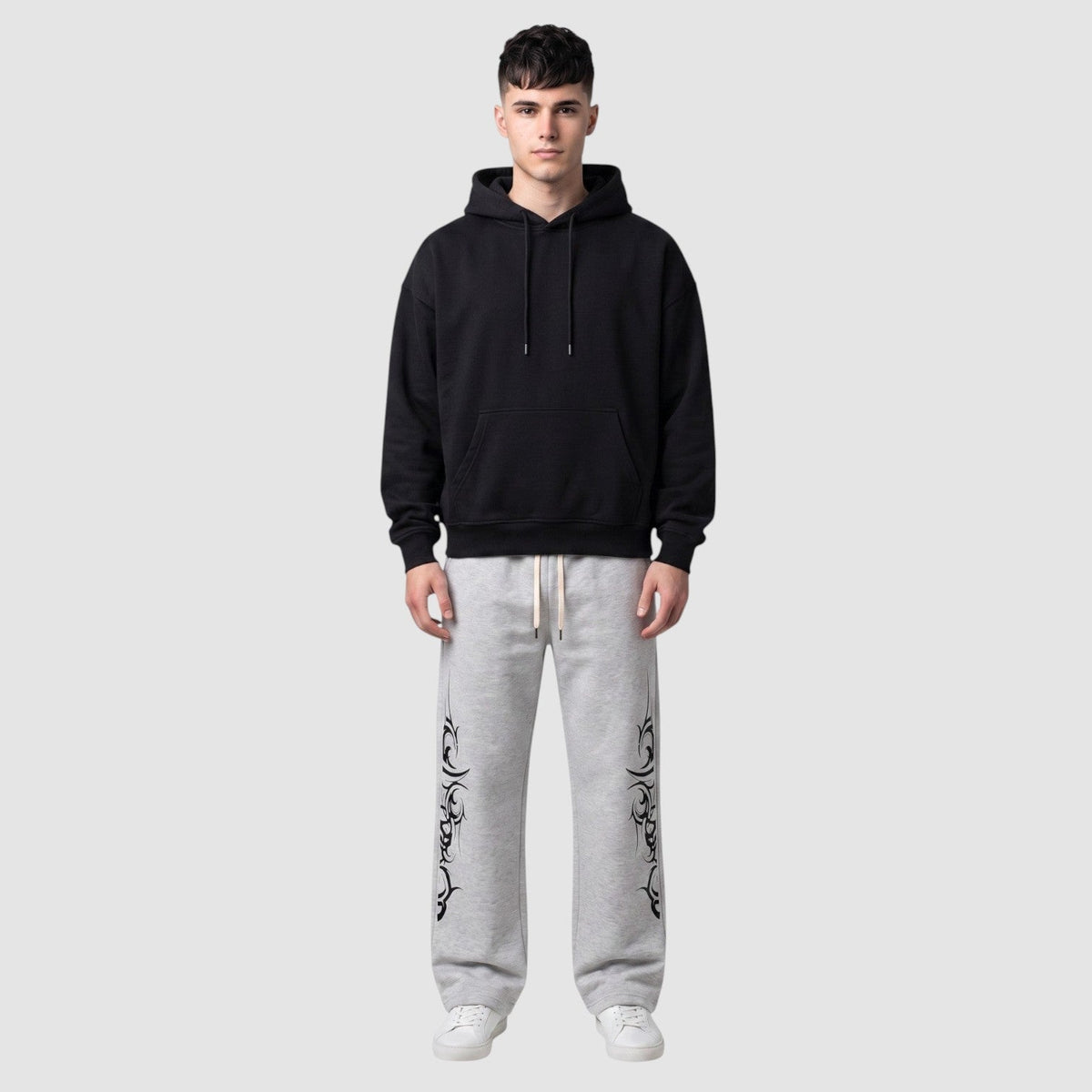 Jogging molletonné chiné gris avec imprimé graphique tribal noir, coupe jambe large et taille ajustable à cordon.