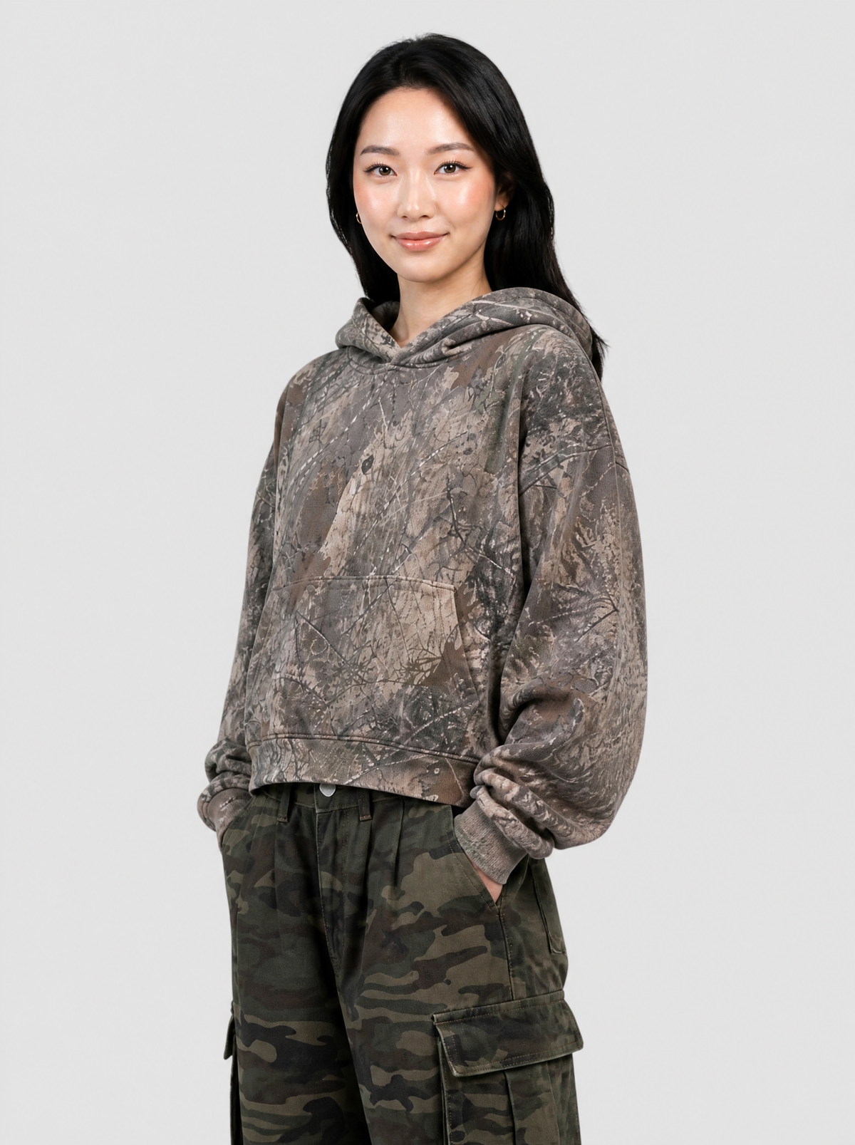 Autre vue | Femme portant le hoodie court à camouflage écorce brun et gris, vu de trois quarts avec un cargo camouflage