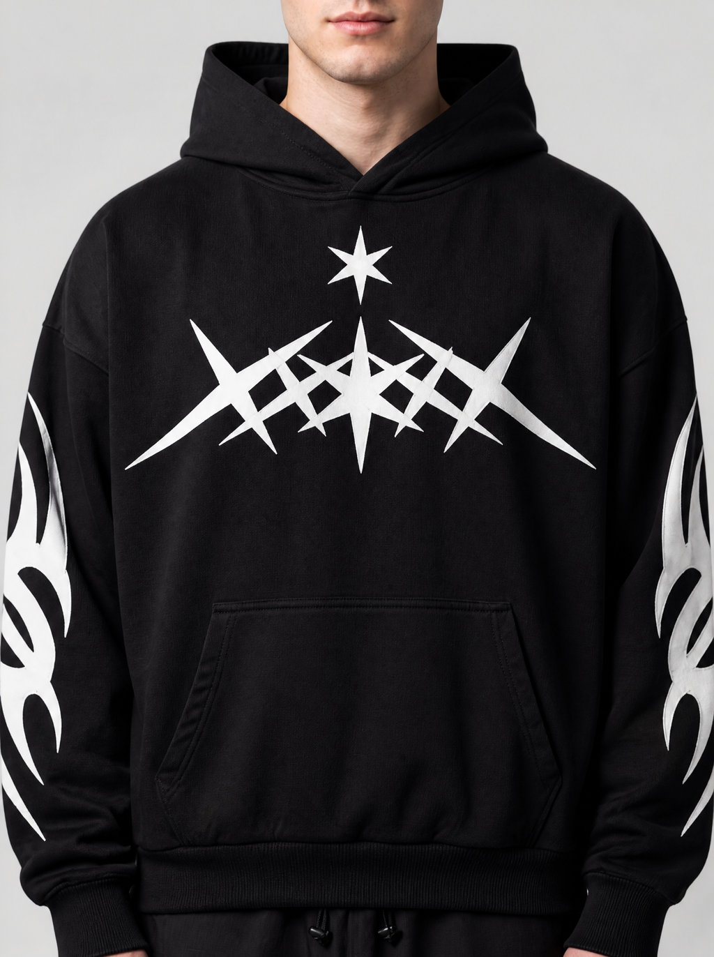 Photo détail | Gros plan sur le motif blanc d'étoiles pointues tribales et la petite étoile sur la poitrine du hoodie noir