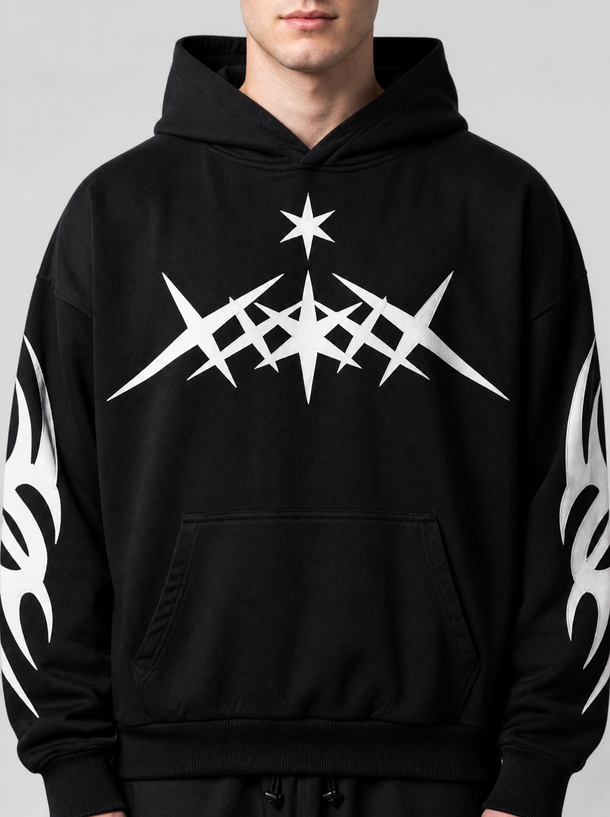 Photo détail | Gros plan sur le motif blanc d'étoiles pointues tribales et la petite étoile sur la poitrine du hoodie noir