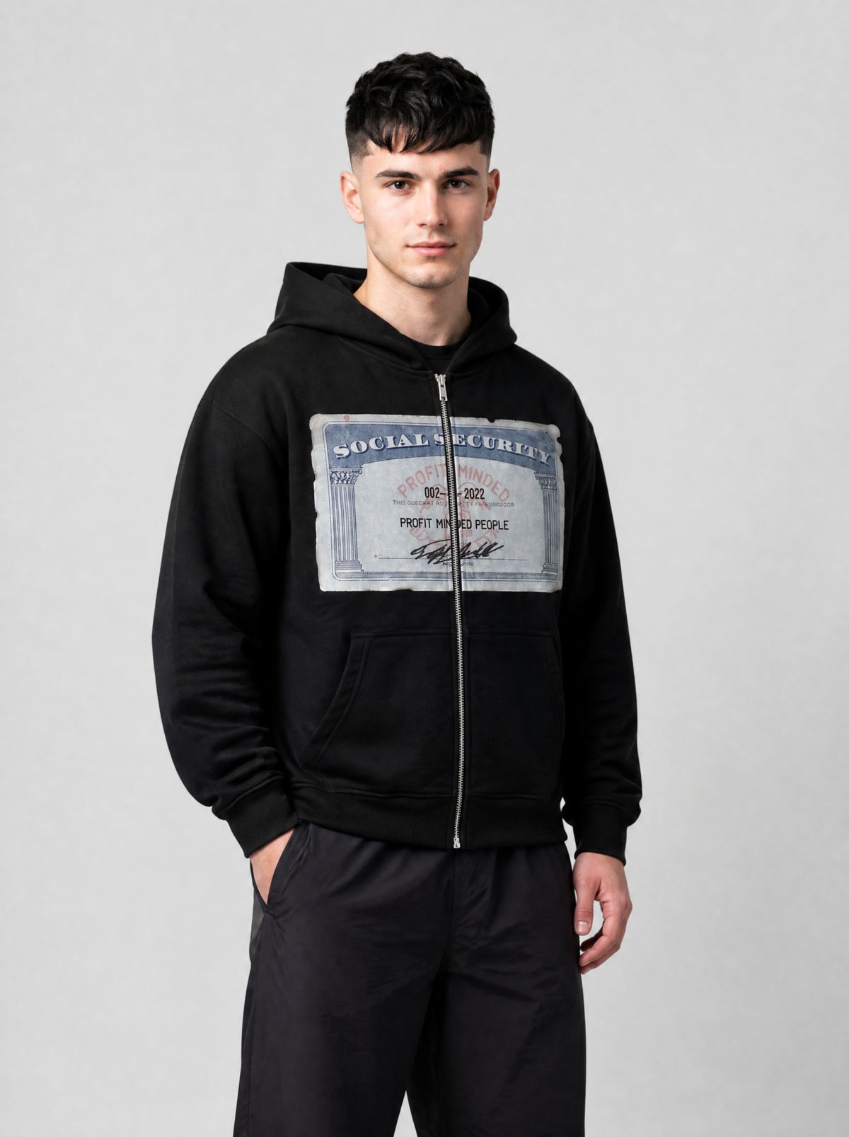Autre vue | Sweat zippé noir court à imprimé carte sécurité sociale porté de trois quarts avec un pantalon parachute noir | Variante : Noir