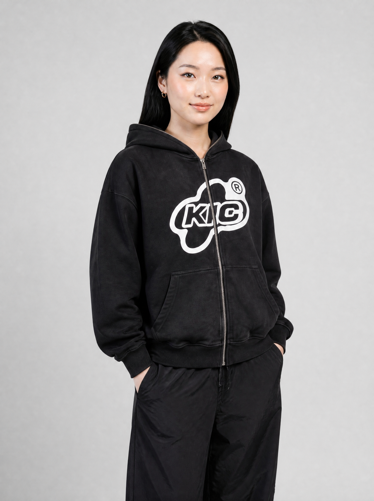 Autre vue | Femme portant le hoodie zippé noir délavé à grand logo ovale blanc KIC, vu de trois quarts avec un parachute noir | Variante : Noir