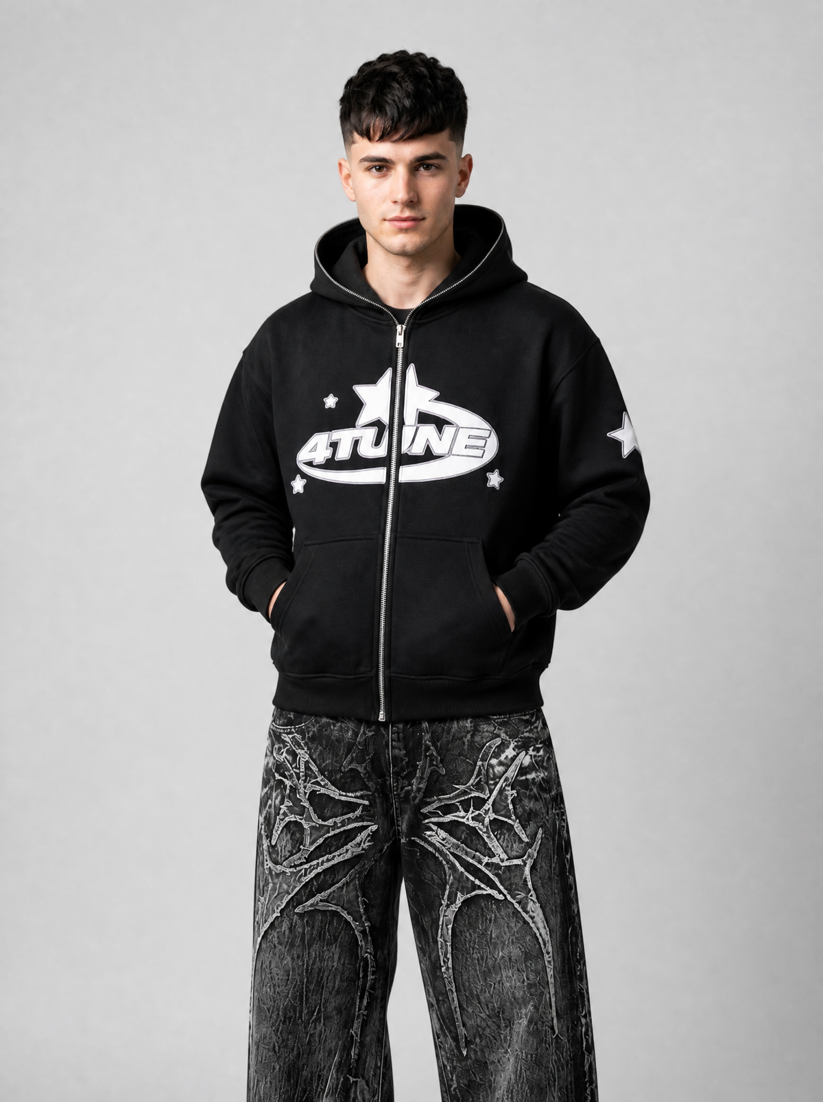 Autre vue | Hoodie zippé noir oversize à logo 4TUNE blanc porté de face, mains dans les poches, avec un jean baggy gris | Variante : Noir