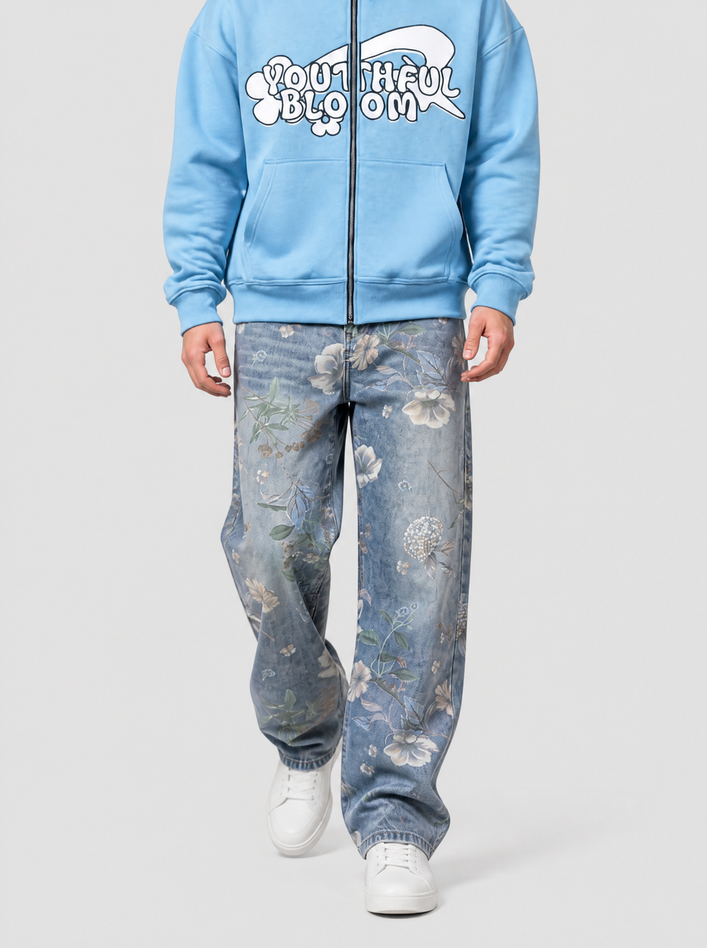 Autre vue | Homme marchant de face en jean large bleu délavé à fleurs beiges, associé à un hoodie zippé bleu ciel avec texte en lettres bulles