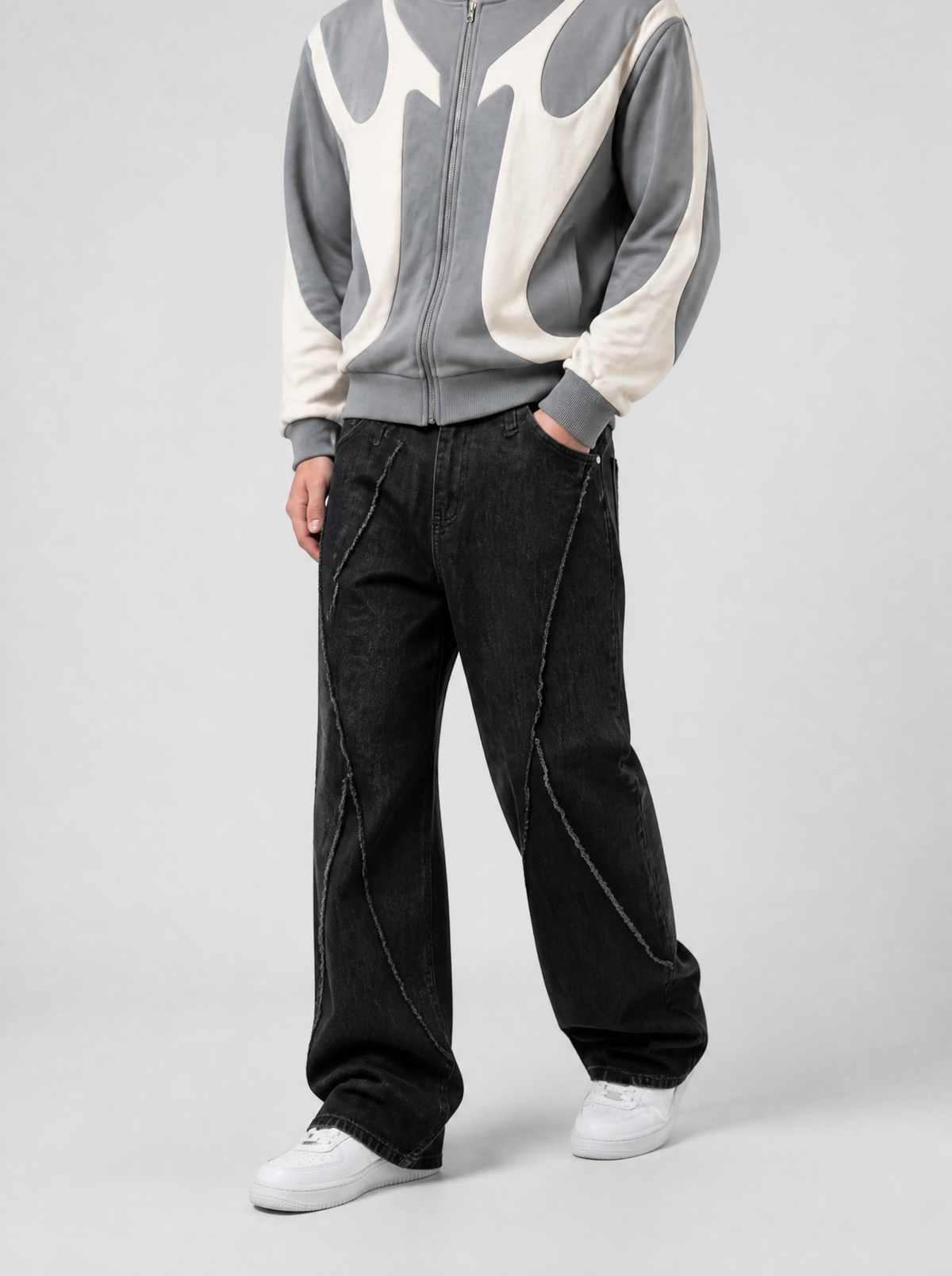 Autre vue | Jean large noir délavé à coutures courbes effilochées, porté de trois quarts face avec un hoodie zippé gris à empiècements crème