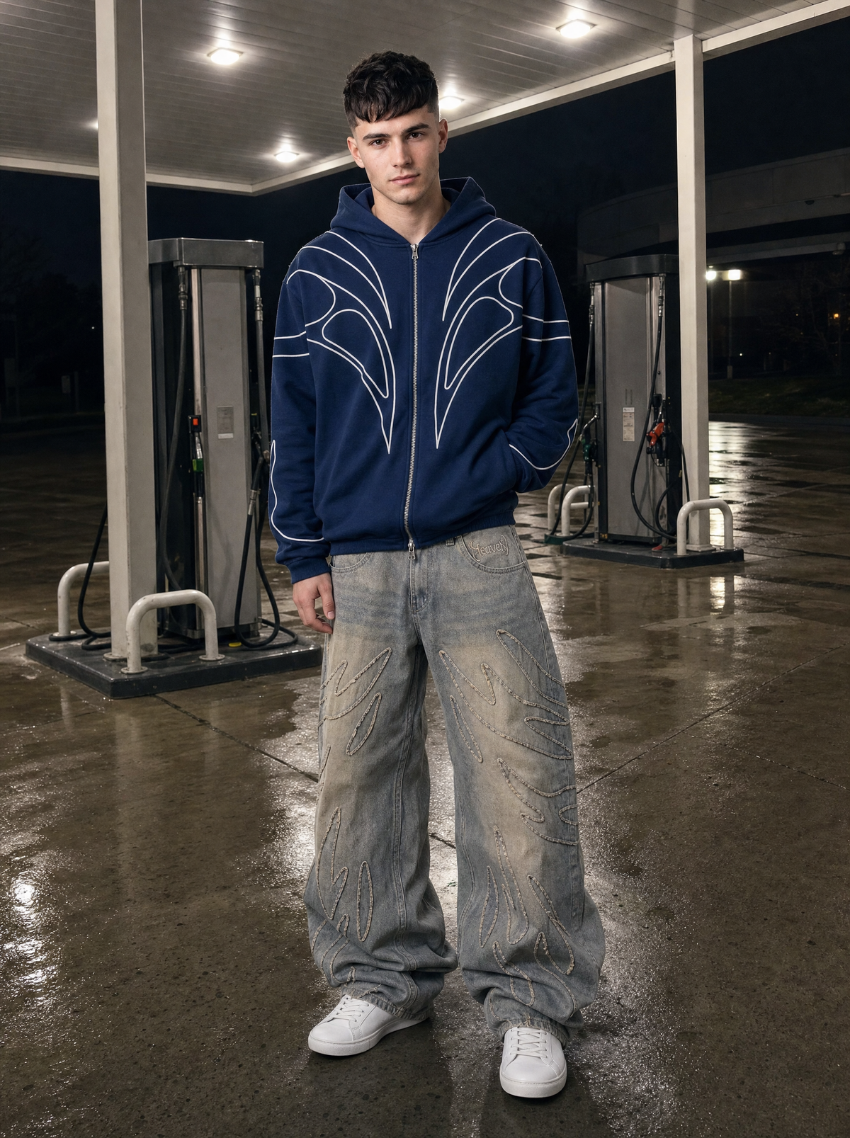 Photo lifestyle | Jean baggy gris délavé à flammes effilochées porté par un homme devant une station-service, photo de rue au flash | Variante : Gris