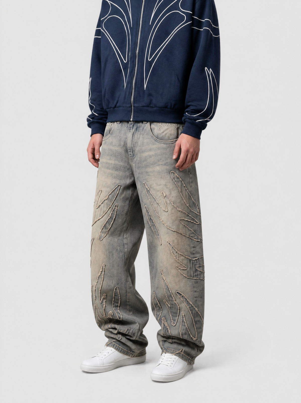 Autre vue | Jean baggy gris délavé à flammes en denim effiloché, porté de trois quarts face avec un hoodie zippé bleu marine à liserés blancs | Variante : Gris