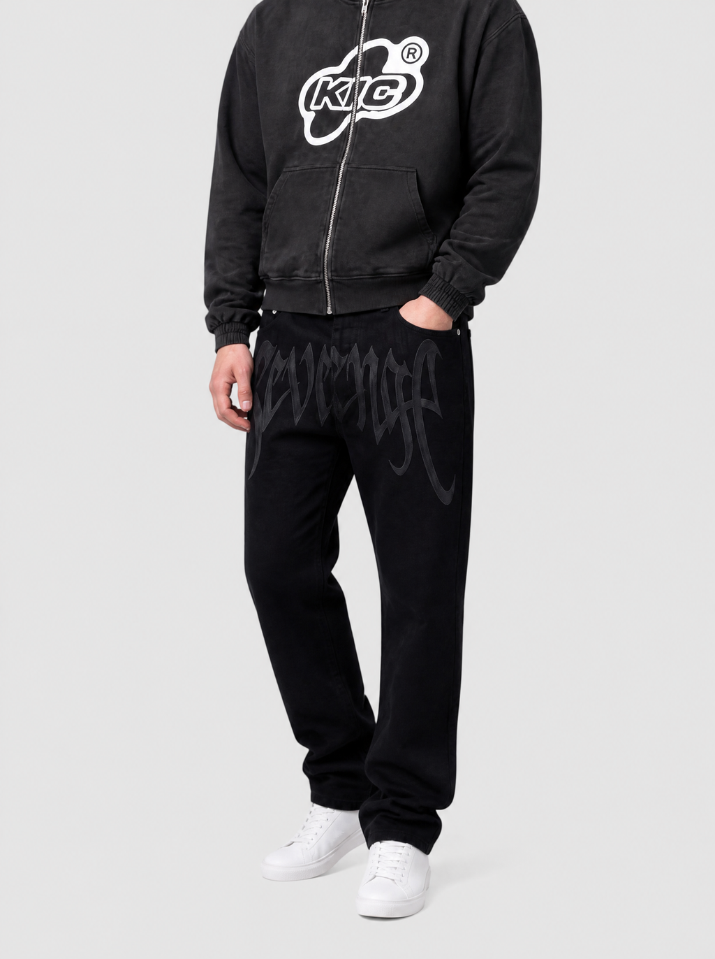 Autre vue | Jean noir droit imprimé Revenge en lettres gothiques grises, porté de trois quarts face avec un hoodie zippé noir à logo blanc