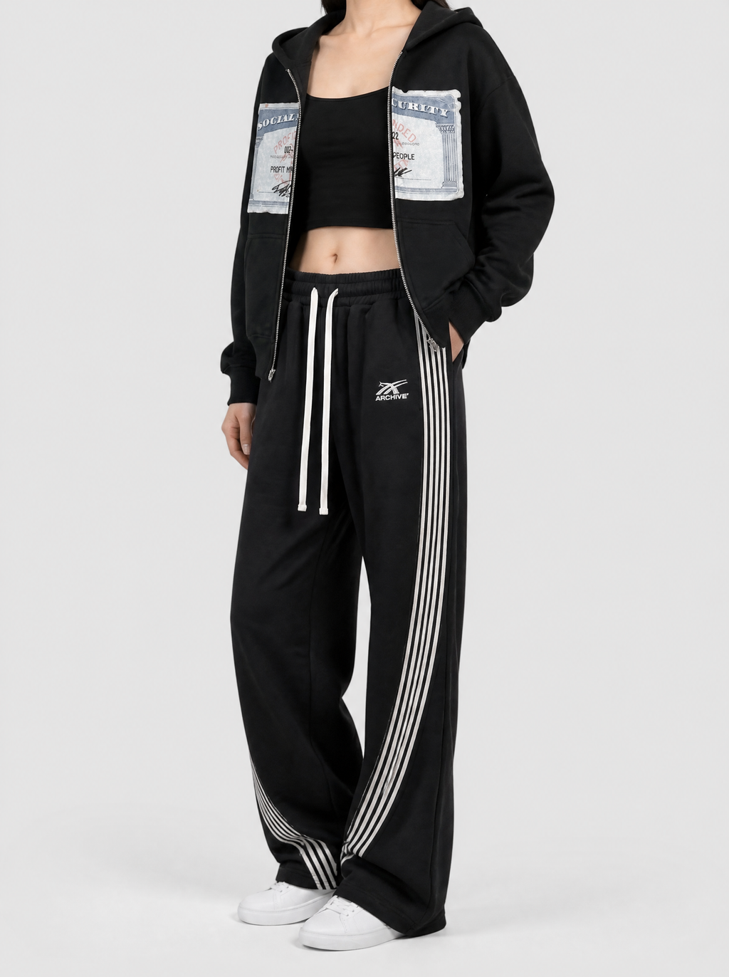Autre vue | Femme portant le jogging large noir à fines bandes blanches courbées, vu de trois quarts | Variante : Noir