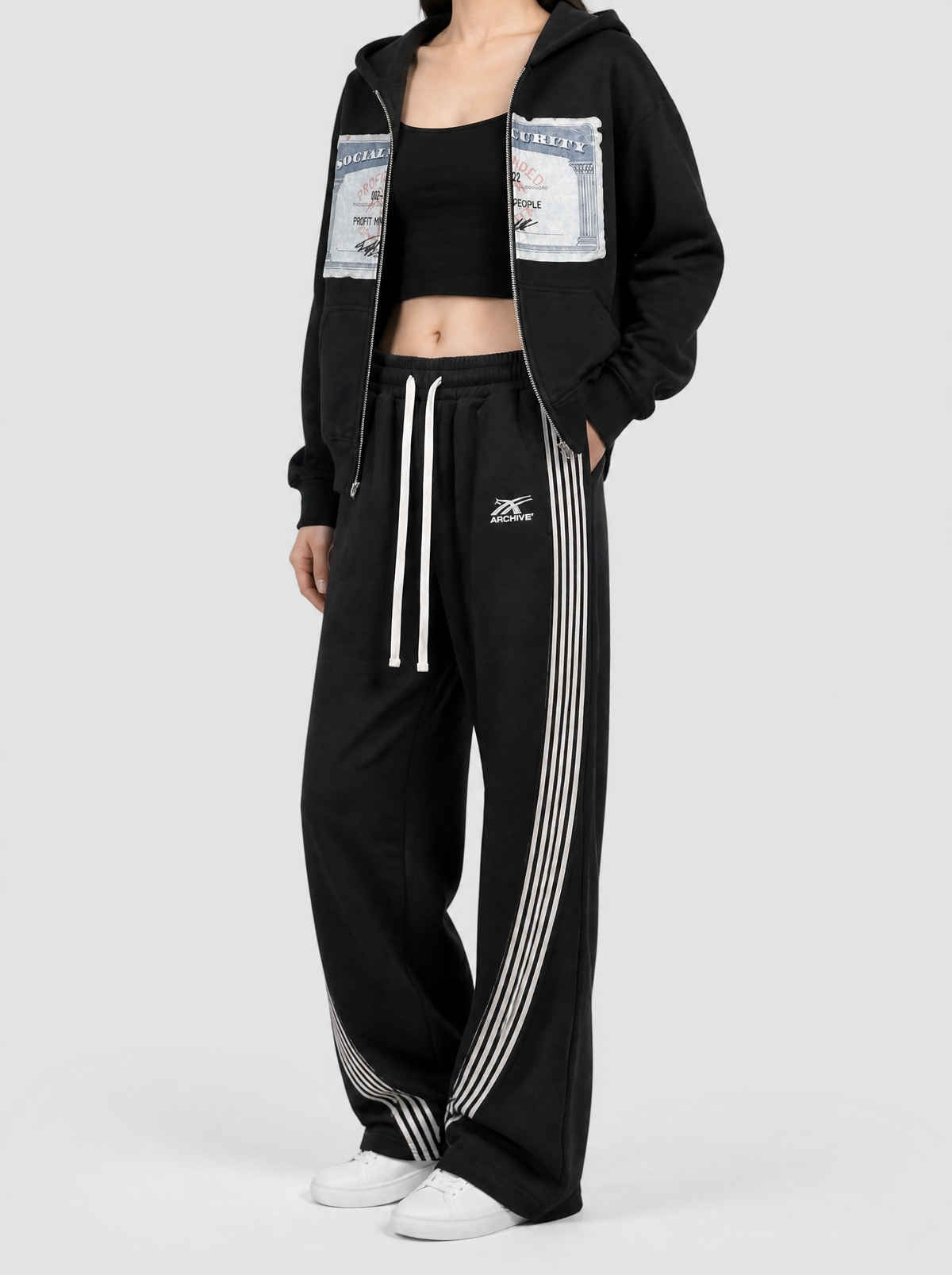 Autre vue | Femme portant le jogging large noir à fines bandes blanches courbées, vu de trois quarts | Variante : Noir