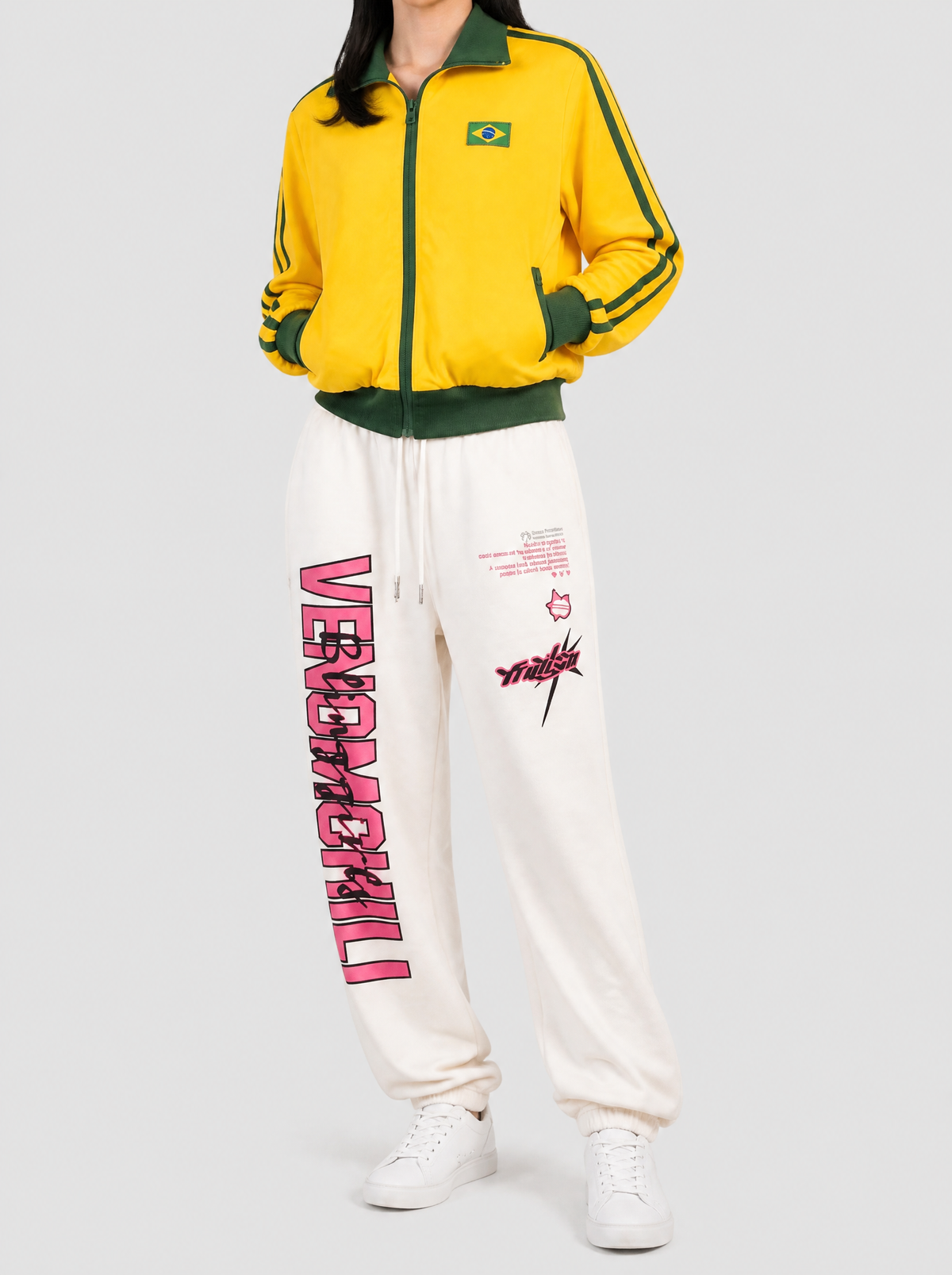 Autre vue | Jogging crème à inscription rose VENOMCHILL sur la jambe, porté de trois quarts face avec une veste de survêtement jaune et verte