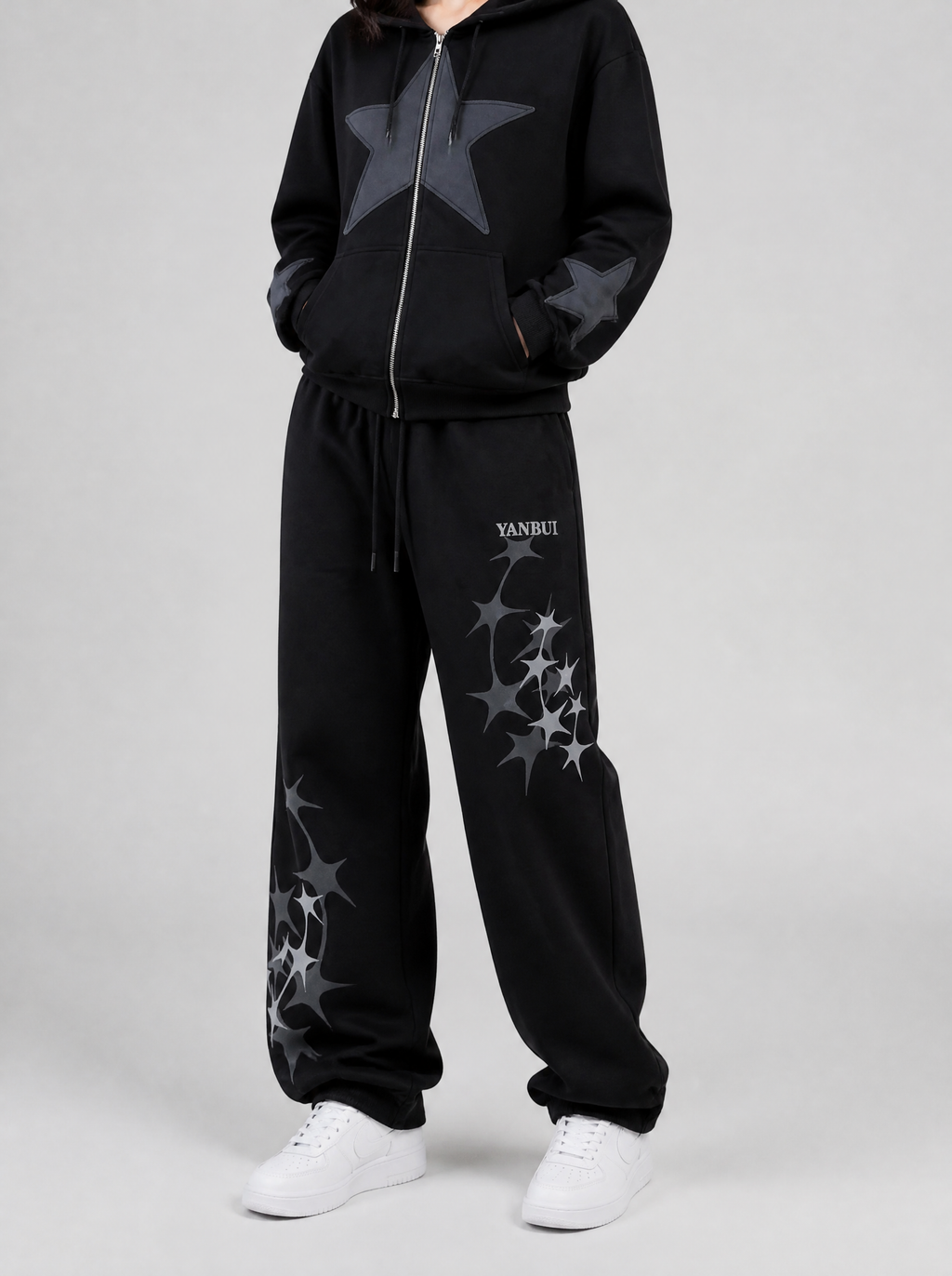 Autre vue | Jogging noir ample à étoiles scintillantes grises, porté de trois quarts face avec un hoodie zippé noir à grande étoile grise