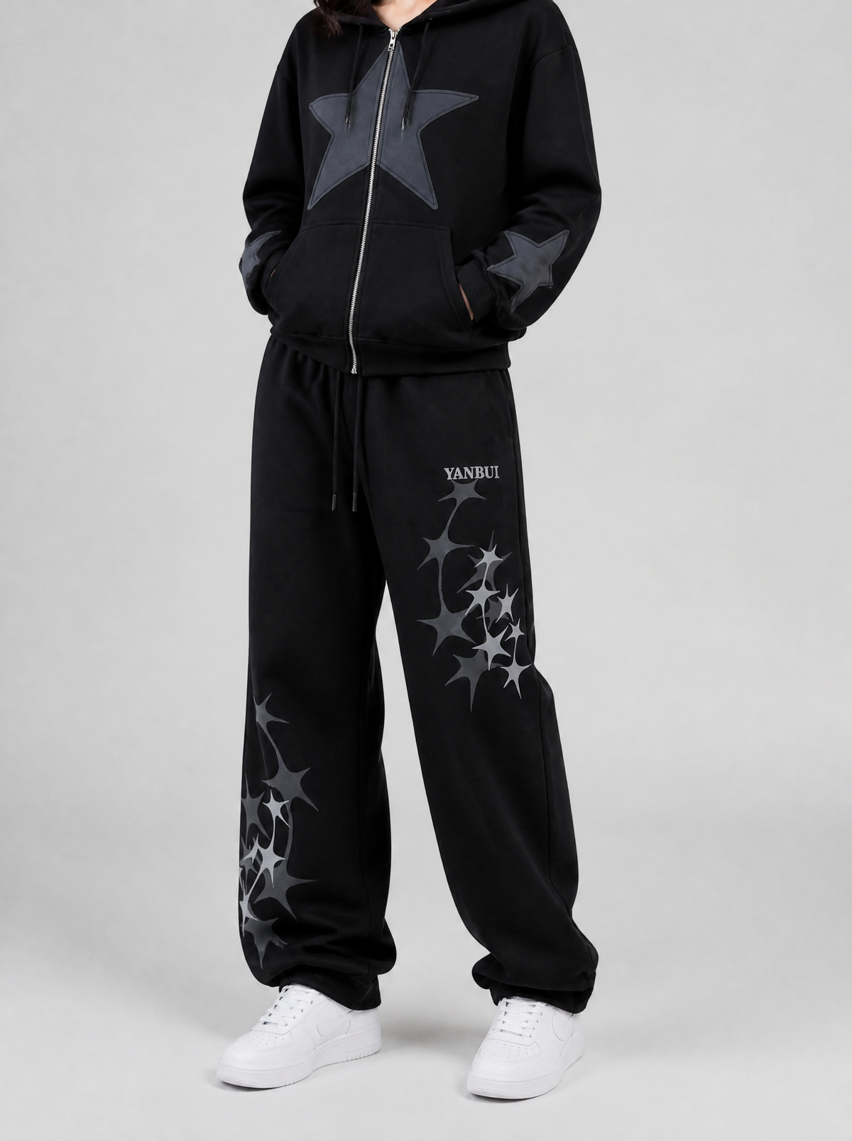 Autre vue | Jogging noir ample à étoiles scintillantes grises, porté de trois quarts face avec un hoodie zippé noir à grande étoile grise