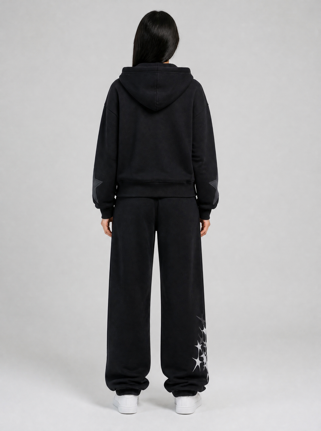 Autre vue | Vue de dos du jogging noir uni avec quelques étoiles grises sur le bas de la jambe, porté avec un hoodie zippé noir étoilé