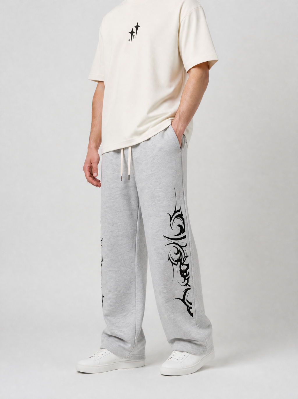 Autre vue | Jogging gris chiné à motifs tribaux noirs sur les côtés, porté de trois quarts face avec un t-shirt blanc cassé à petites croix