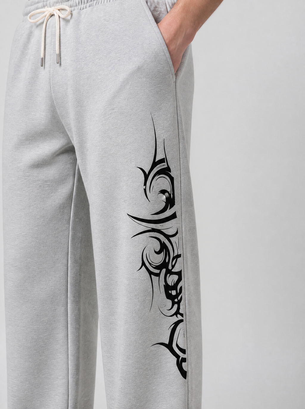 Photo détail | Gros plan sur le motif tribal noir aux pointes acérées imprimé le long de la jambe du jogging gris chiné