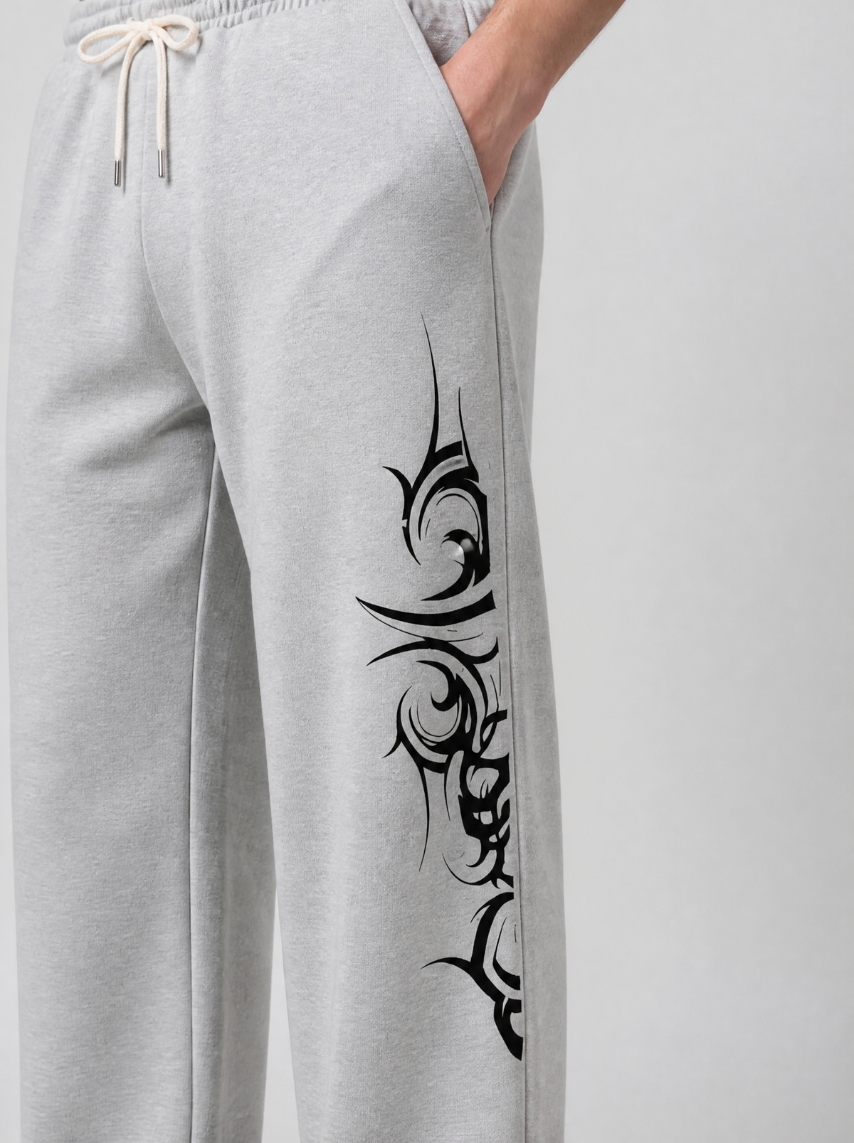 Photo détail | Gros plan sur le motif tribal noir aux pointes acérées imprimé le long de la jambe du jogging gris chiné