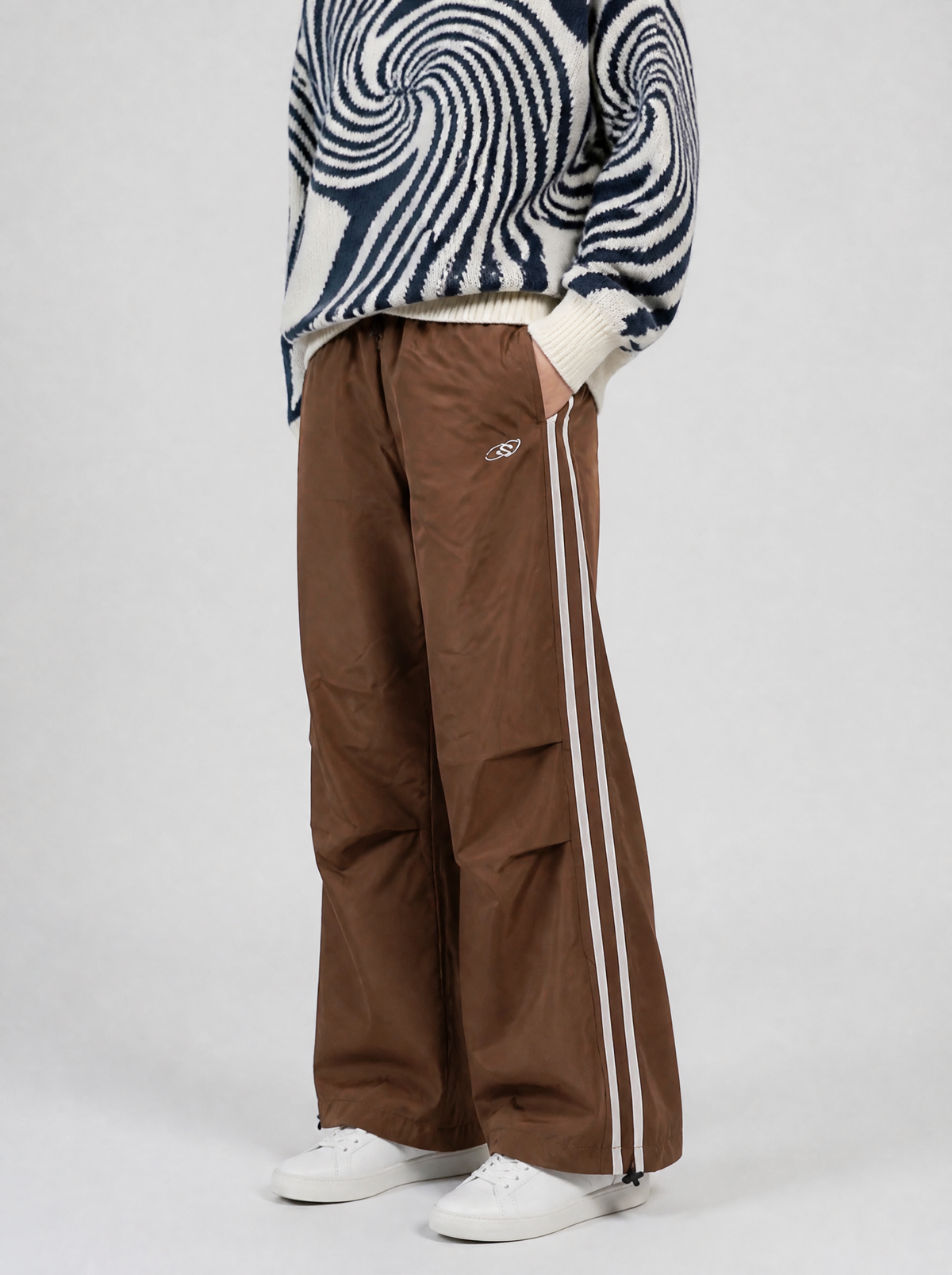 Autre vue | Jogging large marron à doubles bandes blanches latérales porté de trois quarts avec un pull en maille à spirales | Variante : Marron