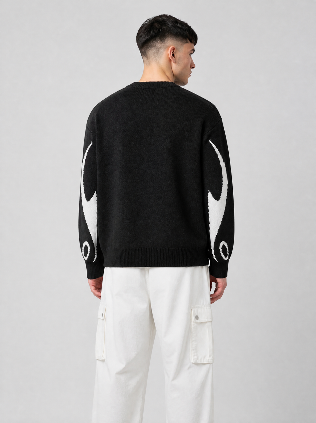 Autre vue | Vue de dos du pull en maille noir au dos uni, flammes blanches sur les manches, porté avec un pantalon cargo blanc | Variante : Noir