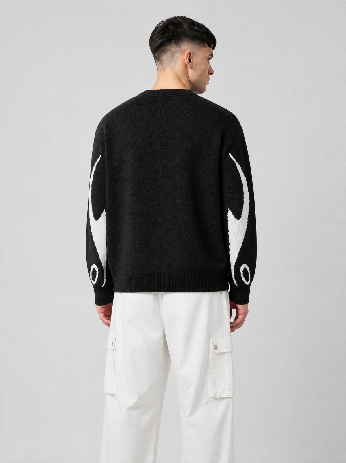 Autre vue | Vue de dos du pull en maille noir au dos uni, flammes blanches sur les manches, porté avec un pantalon cargo blanc | Variante : Noir