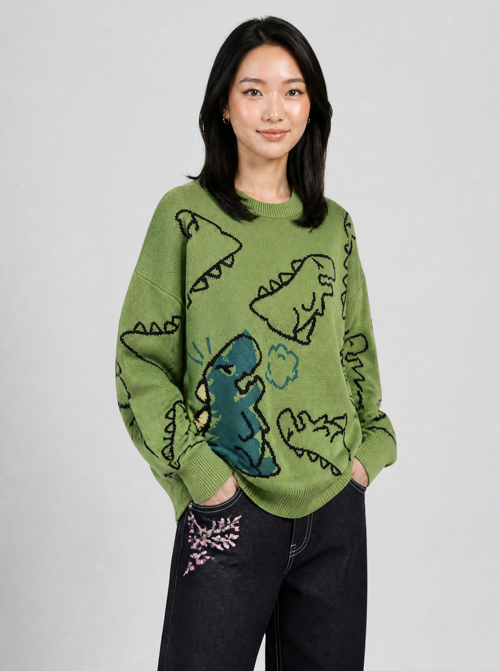 Autre vue | Femme portant le pull en maille vert à dinosaures noirs et grand dinosaure bleu canard, vu de trois quarts | Variante : Vert