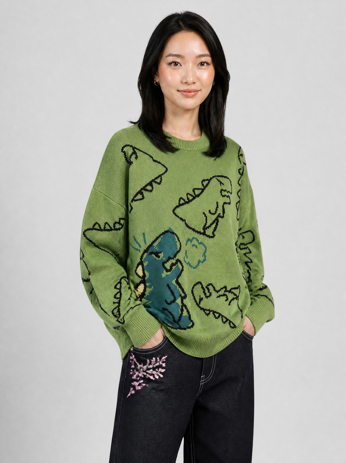 Autre vue | Femme portant le pull en maille vert à dinosaures noirs et grand dinosaure bleu canard, vu de trois quarts | Variante : Vert
