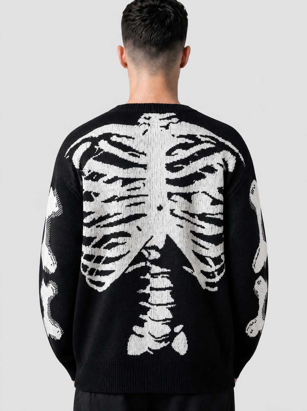 Photo détail | Gros plan de dos sur la cage thoracique et la colonne en jacquard blanc tricotées sur le pull en maille noir | Variante : Noir