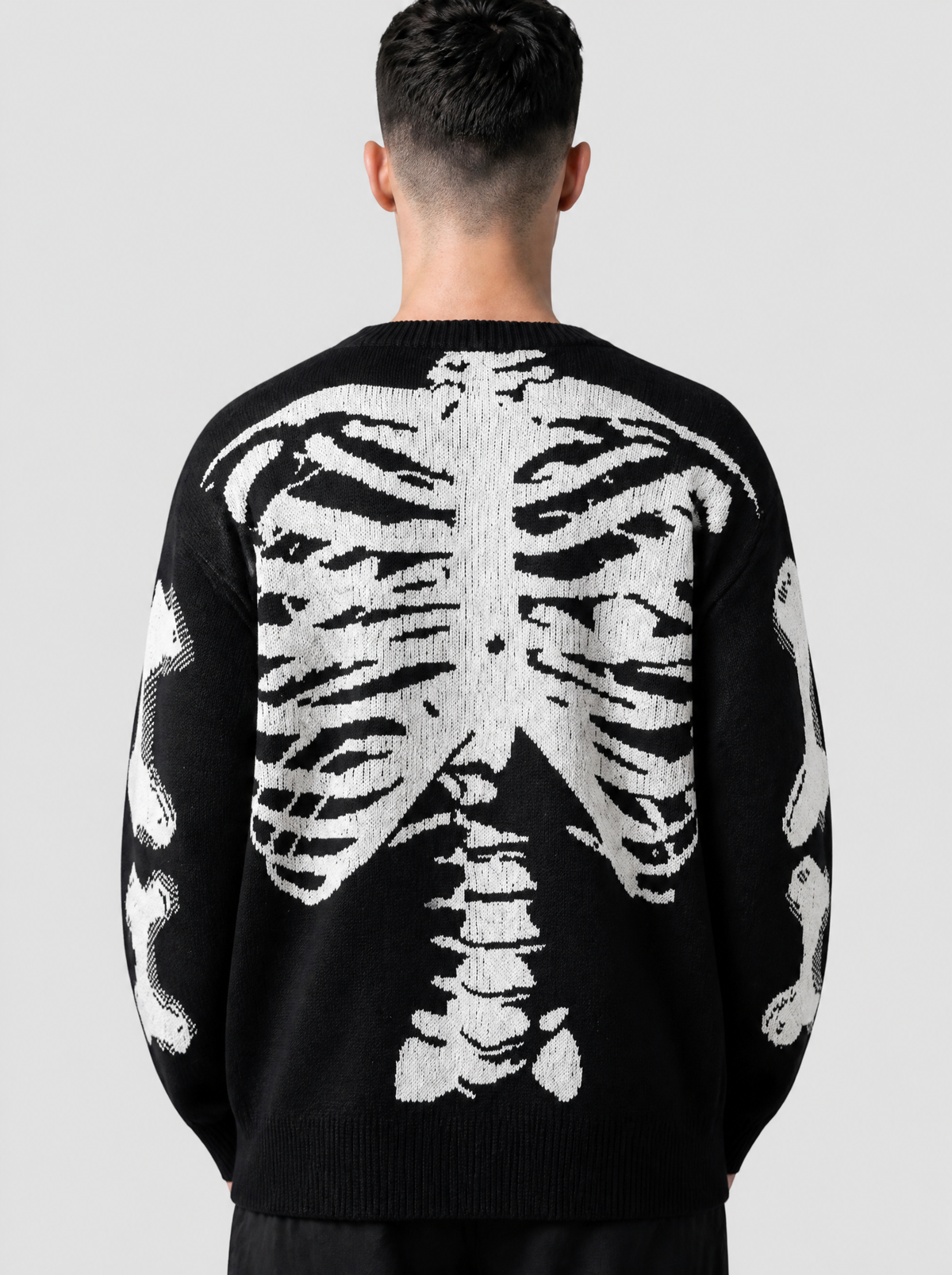 Photo détail | Gros plan de dos sur la cage thoracique et la colonne en jacquard blanc tricotées sur le pull en maille noir | Variante : Noir