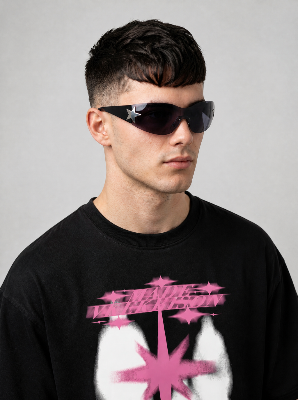 Autre vue | Lunettes masque sans monture verre gris fumé, branches noires et étoile argentée, portées de trois quarts par un homme en t-shirt noir | Variante : Noir