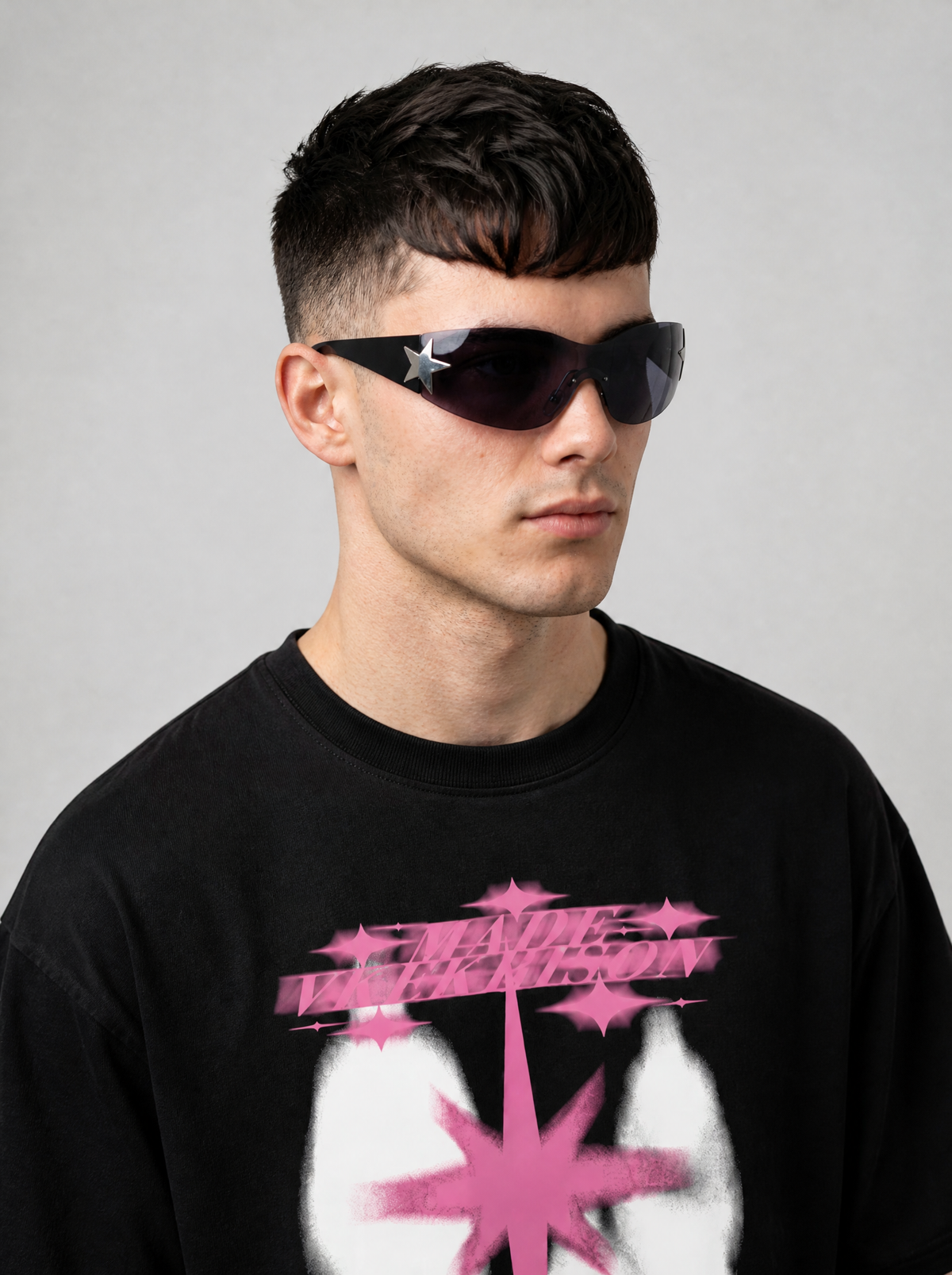 Autre vue | Lunettes masque sans monture verre gris fumé, branches noires et étoile argentée, portées de trois quarts par un homme en t-shirt noir | Variante : Noir