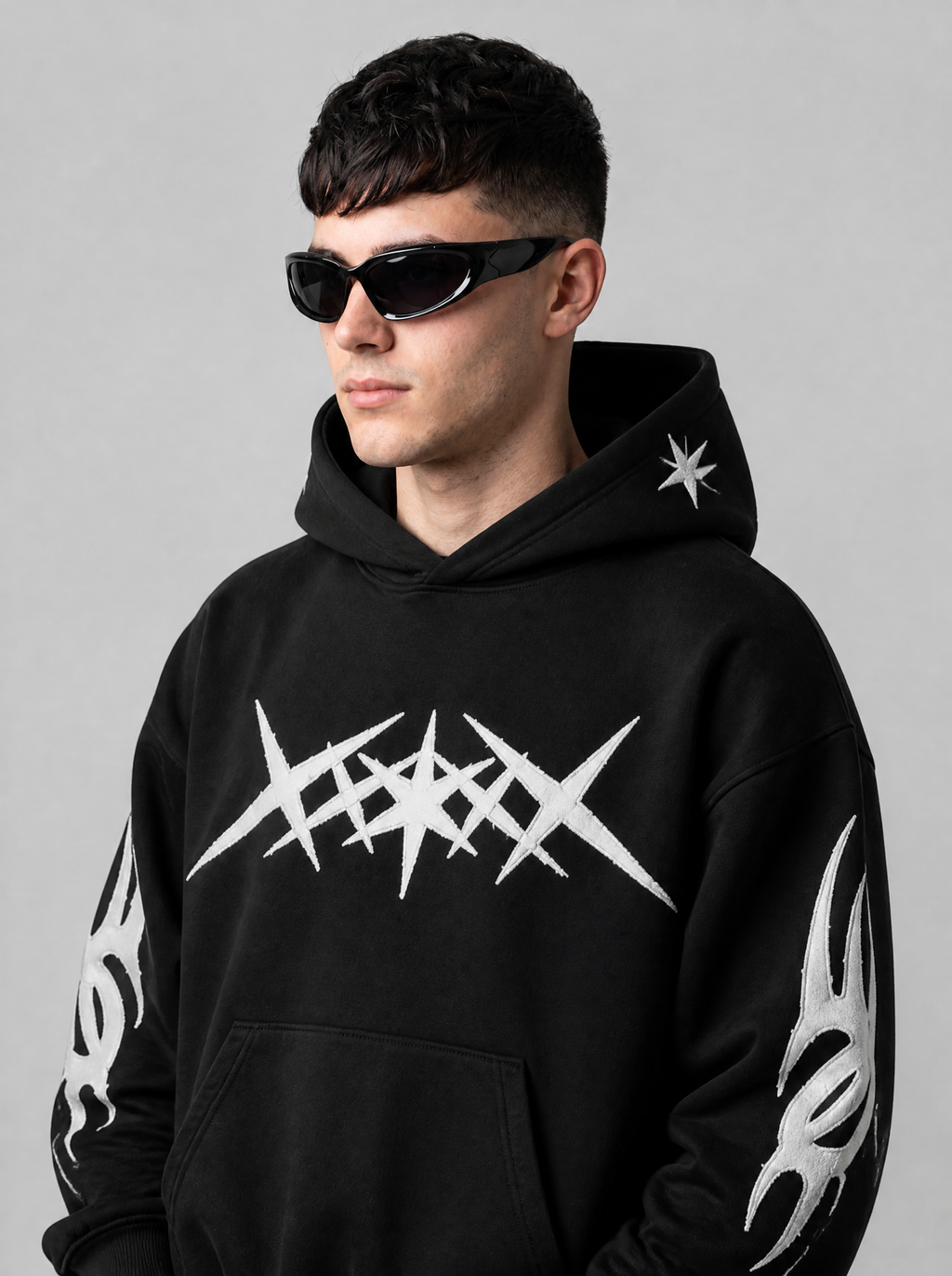 Autre vue | Lunettes de soleil enveloppantes noir brillant verres gris fumé, portées de trois quarts par un homme en hoodie noir graphique blanc | Variante : Noir