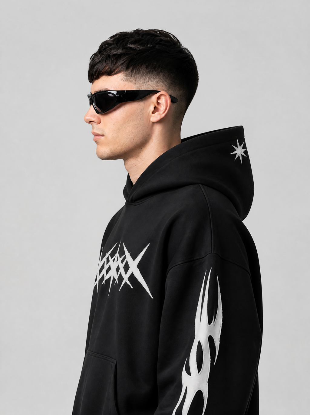Autre vue | Profil des lunettes sport enveloppantes noires brillantes avec jonction sculptée des branches, homme en hoodie noir à motifs blancs | Variante : Noir