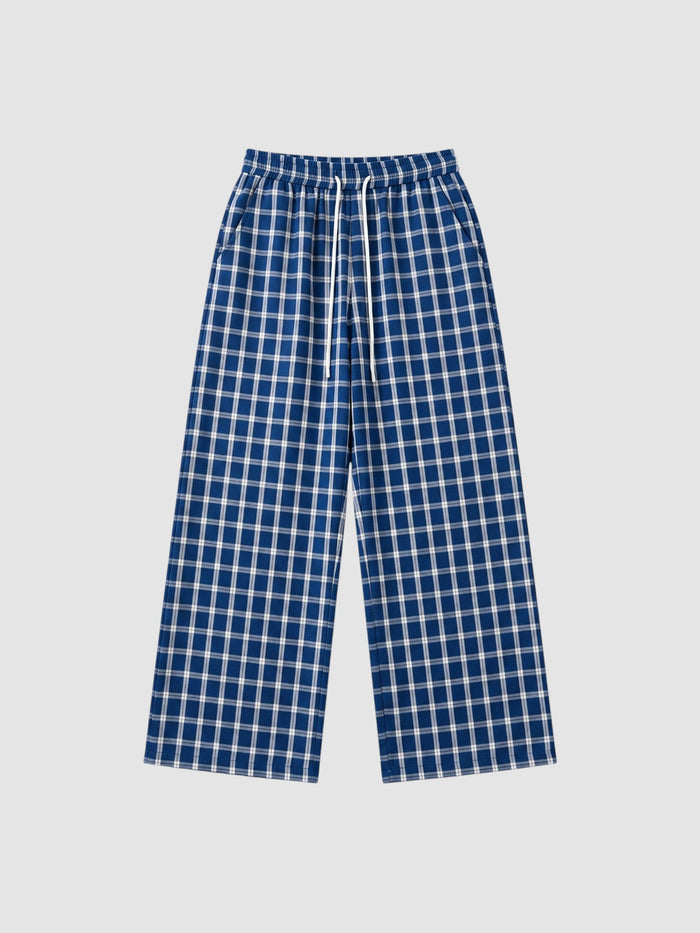 Pantalon jambe large à carreaux bleu marine et blanc avec taille élastique à cordon et poches latérales.