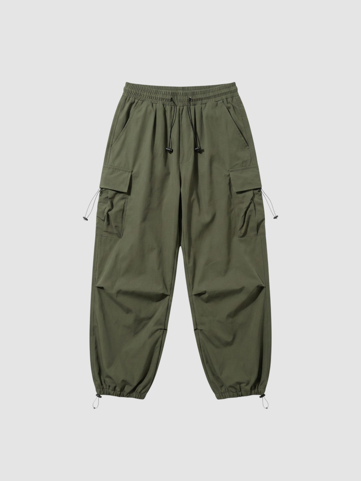 Pantalon cargo parachute vert kaki avec taille élastique, poches à rabat sur les côtés et cordons de jambe ajustables.