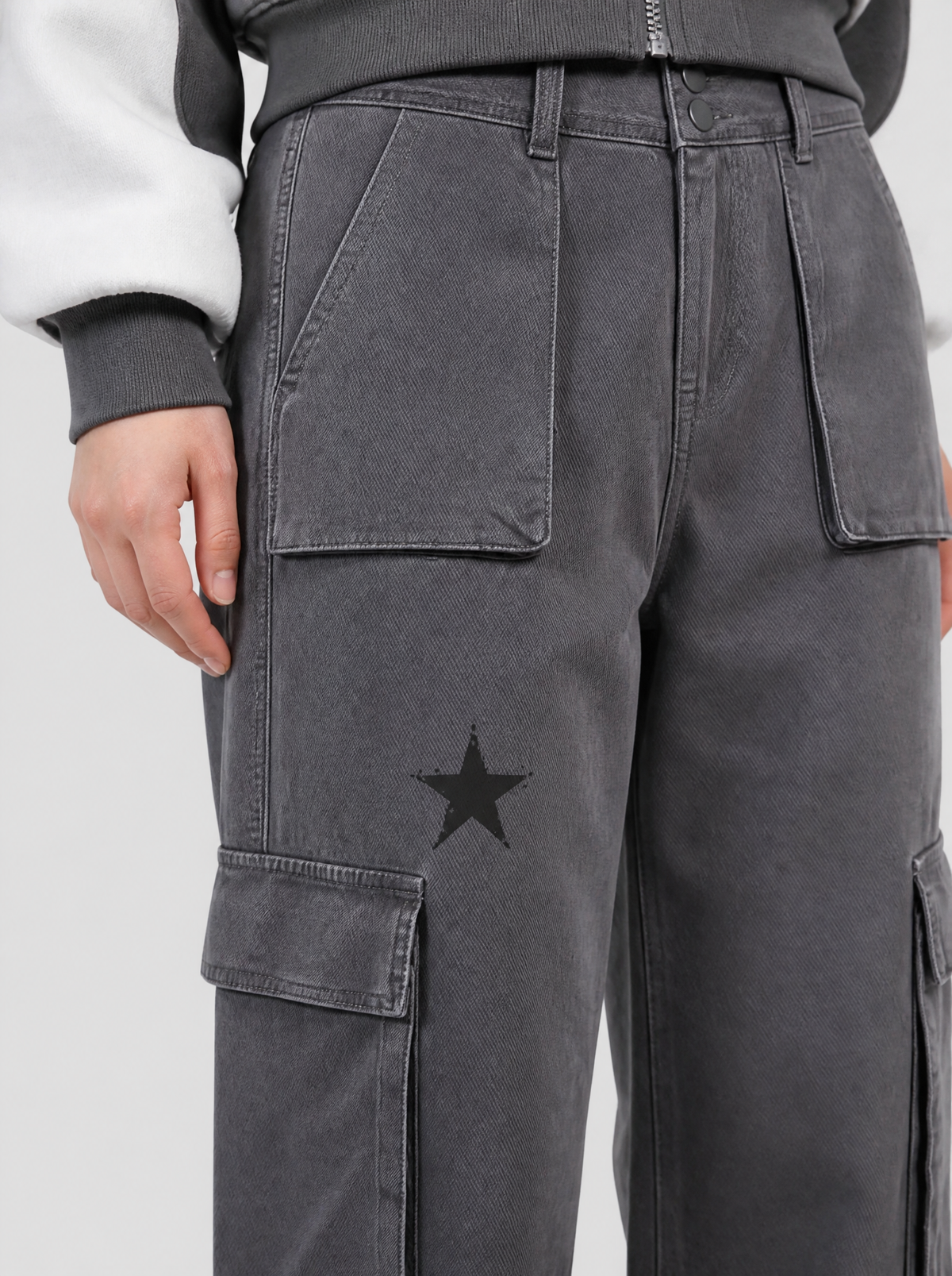 Photo détail | Gros plan sur une étoile noire imprimée et la poche cargo à rabat du pantalon gris délavé taille haute