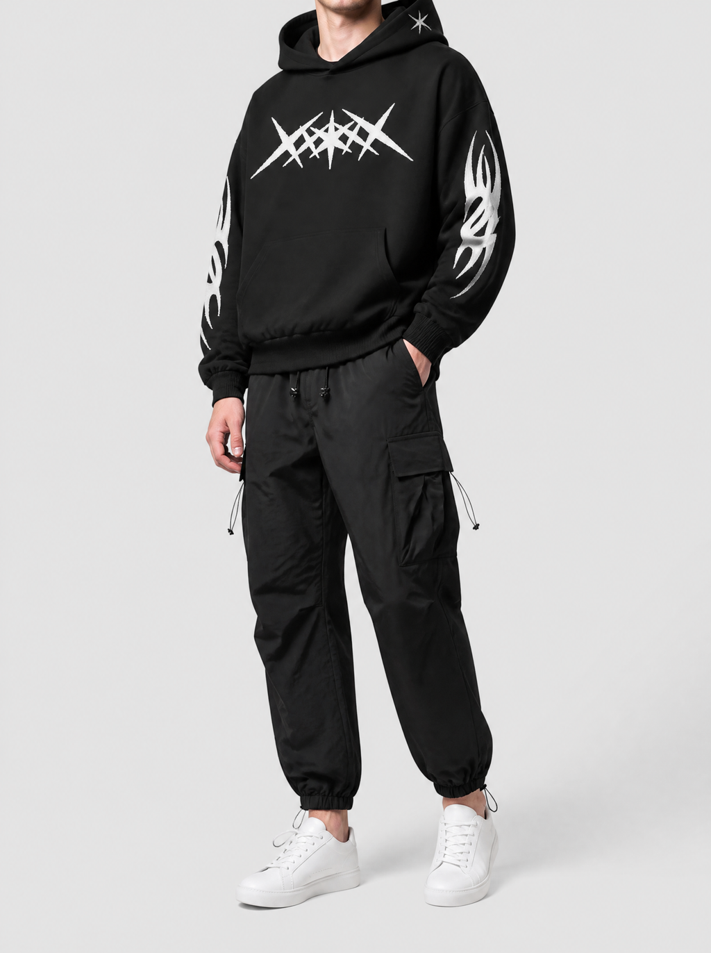 Autre vue | Pantalon cargo parachute noir à poches à rabat et chevilles élastiquées, porté de trois quarts avec un hoodie noir graphique | Variante : Noir