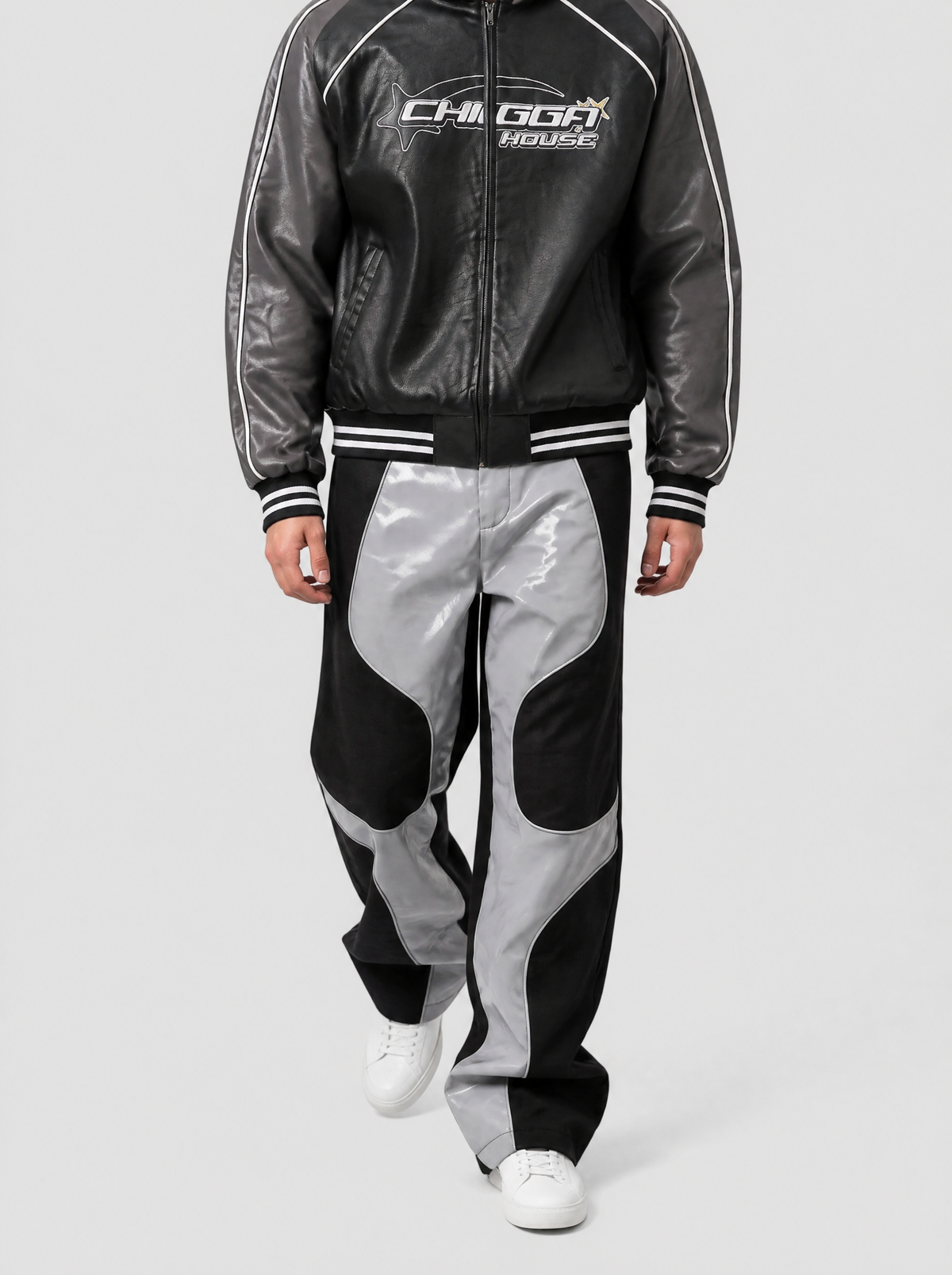 Autre vue | Homme marchant de face en pantalon moto noir et gris verni à découpes courbées, porté avec un blouson simili cuir noir